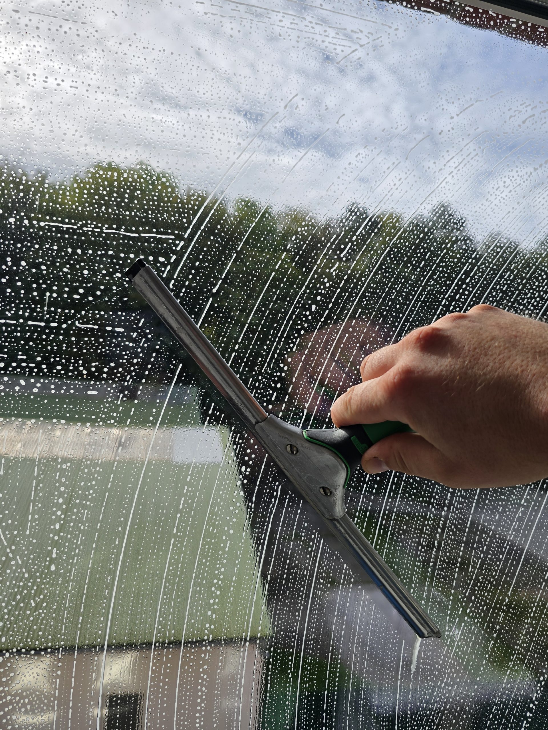 Fenster wird mit einem Abzieher gereinigt Leistungen